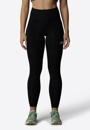 Black training leggings with a high waistband, made from stretchy fabric, featuring zippered pockets and subtle logo details.