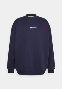 Felpa blu navy con colletto a girocollo, polsini a coste e un piccolo logo rosso e bianco sul petto. Realizzata in morbido tessuto di cotone texturizzato.