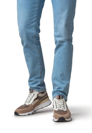 Zapatillas deportivas con parte superior de malla multicolor y gamuza, con suela gruesa en blanco y marrón claro; cordones y detalles sutiles en el patrón.