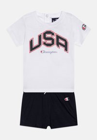 White cotton t-shirt with "USA" and "Champion" logo in black and red, paired with navy blue shorts featuring an embroidered logo.