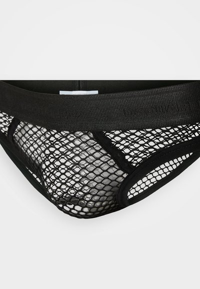 Schwarzer Netz-Tanga mit breitem Taillenbund und Logo. Das Design umfasst ein geometrisches Muster und bietet eine halbtransparente Textur.