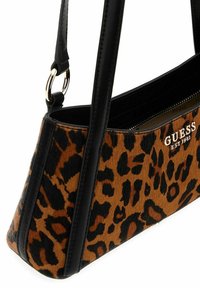 Borsa con stampa leopardata, dotata di una elegante tracolla in pelle nera e dettagli coordinati; presenta una chiusura zip e un logo su un lato.