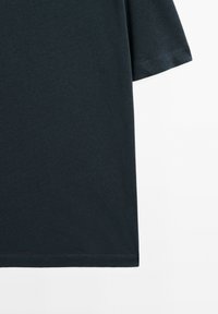 Svart kortärmad t-shirt i bomull. Rundad halsringning och rak nederkant. Slät textur utan synliga mönster eller dekorationer.