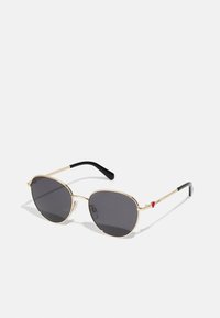 Gold-framed sunglasses with grey lenses, oval shape, featuring black temple tips and a red accent detail on the right side.