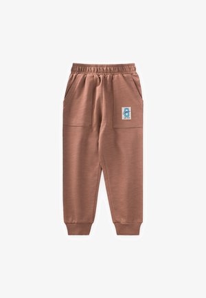 Pantalons de jogging marron avec une taille élastique, poches latérales et un patch avec un numéro bleu. Texture lisse et bas fuselés.