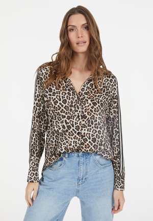 Leopard-print button-up shirt with long sleeves, black buttons, and contrasting stripes along the sides; lightweight fabric. Worn with blue jeans.
