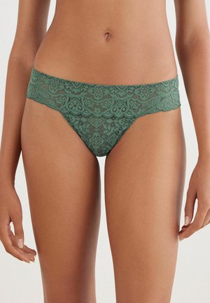 Groene kantstring met een brede kanten tailleband met bloemmotieven. Gladde textuur, zijuitsnijding en ingewikkelde details overal.