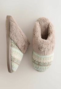 Chausson tricoté avec un col en peluche beige doux, présentant un dessus texturé multicolore dans des teintes pastel et une semelle plate beige.