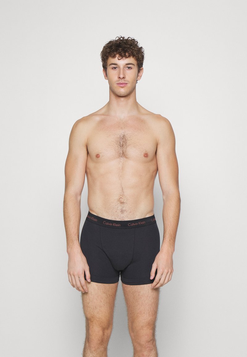 Svarte boxershorts med Calvin Klein-logo i midjen. Myk stoff, tettsittende design og lengde til midten av låret med glatt tekstur.
