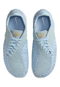 Lichtblauwe sneakers met een geweven textielontwerp, met een gladde bovenkant en veters, accentueert met een gouden Nike-logo op de tong.