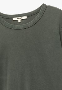 Mørkegrøn bomulds t-shirt med rund halsudskæring og korte ærmer. Glat tekstur, ingen synlige mønstre eller detaljer. Etikette med størrelse og mærke.