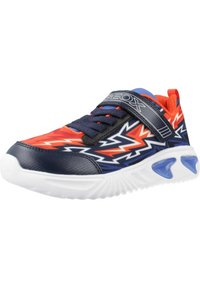 Zapatilla deportiva azul y naranja con un patrón en zigzag, una correa de Velcro, material sintético texturizado y una suela de goma blanca con acentos azules.