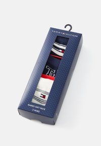 Pack de regalo de calcetines para bebés Tommy Hilfiger en una caja azul marino. Contiene tres pares: azul marino, blanco y rojo con rayas y detalles con el logo.
