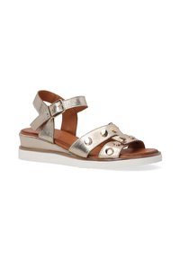 Metallic guld sandaler med kilehæle, der har dekorative nitter og ankelstropper. Velegnet til afslappet og sommerbrug.