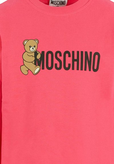 Felpa rosa con scollo rotondo, caratterizzata da una grafica di un orso in stile cartoon e un testo "MOSCHINO" in tan e nero sottostante. Materiale in cotone.