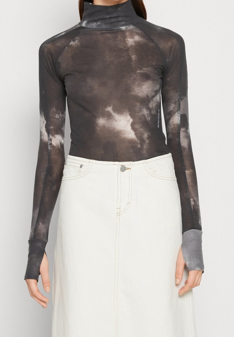 Pitkähiha, vartalonmyötäinen tummanharmaa poolopaita, jossa on pilvimäisiä valkoisia kuvioita; sisältää peukalonreiät hihoissa, valmistettu pehmeästä, kevyestä materiaalista.