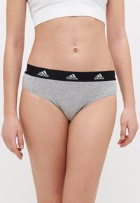 Šedé bavlněné spodní prádlo s černým pasem a bílými logy Adidas. Design je jednoduchý a přiléhavý, ideální pro každodenní nošení.