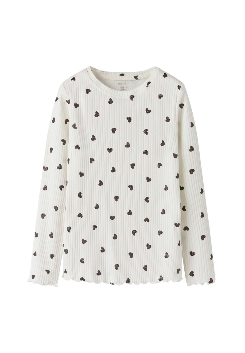 Pikakäised valge topp ribatud kangast, millel on väiksed pruunid südame mustrid, lainelise äärega ja ümmarguse kaelusega.