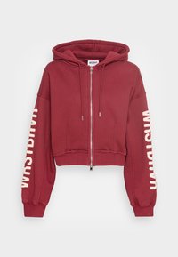 Lyhennetty viininpunainen huppari etuvetoketjulla, suurella hupulla ja pitkillä hihoilla, joissa on tekstuurista kermaista kirjontaa oikeassa hihassa.