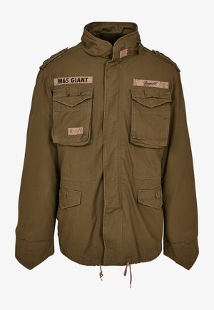 Chaqueta M65 verde oliva con cuello alzado, dos bolsillos en el pecho, cordón ajustable en la cintura y parches cosidos en los hombros.