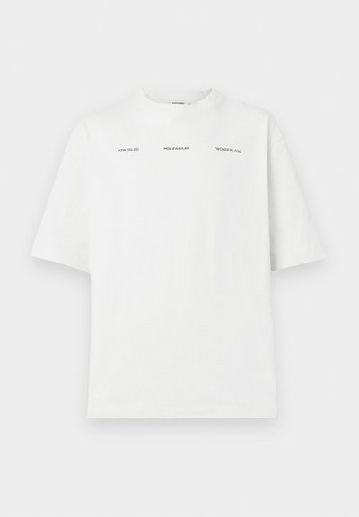 Camiseta blanca de algodón con un corte relajado, escote redondo, mangas cortas y etiquetas de texto en negro. Sin patrones ni gráficos.