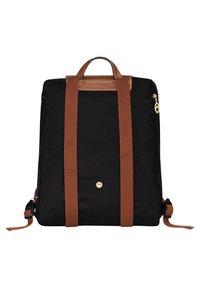 Schwarzer Rucksack mit braunen Riemen und Griff, goldenen Reißverschlussdetails und vorderem Knopfverschluss, aufrecht vor weißem Hintergrund dargestellt.