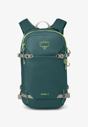 Sac à dos bleu sarcelle avec des accents jaunes, des bretelles rembourrées, une poignée supérieure et des sangles à boucle ajustables. Dispose d'un grand compartiment avant.