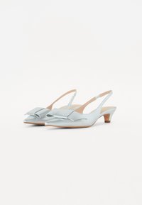 Chaussures slingback bleu clair avec un bout pointu, ornées d'un nœud décoratif et d'un petit talon carré. Texture lisse avec une finition satinée.