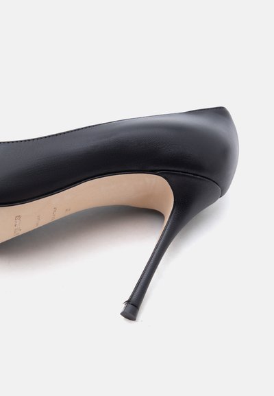 Μαύρο δερμάτινο γοβάκι με ψηλό τακούνι, εμφανίζεται από το πλάι, τονίζοντας το λεπτό στιλέτο τακούνι και την μπεζ εσωτερική σόλα.