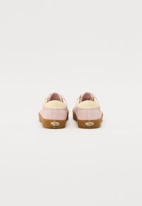 Rosa mockasalomonsneakers med en krämfärgad läderhælaccent. Har en tan gummisula och detalj med logotyp bak. Rundad form med snörning.