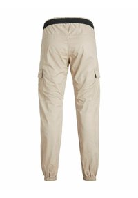 Pantalon cargo beige clair avec poignets élastiques et taille élastique noire, vu de dos sur fond blanc.