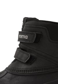 Fekete téli csizma szintetikus anyagból, két tépőzárral, párnázott szegéllyel és varrott részletekkel a talp mentén.
