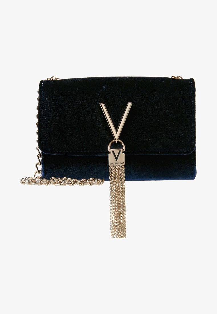 Navy blue velvet bag with gold hardware featuring a large "V" logo and a chain detail with tassels. Flap closure with a textured finish.