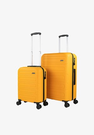 Conjunto de equipaje rígido amarillo, con superficie texturizada, asas telescópicas plateadas y cuatro ruedas negras para facilitar la movilidad.