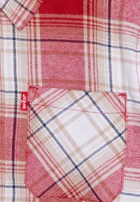 Rot-beige kariertes Hemd mit einer Brusttasche, strapazierfähiger Stoffstruktur und einem kleinen roten Levi's-Tag an der Seitennaht.