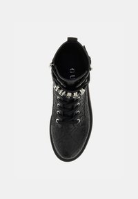 Sneaker nera alta realizzata in materiale sintetico testurizzato, caratterizzata da lacci sulla parte anteriore, chiusura con zip e dettagli in metallo argentato.
