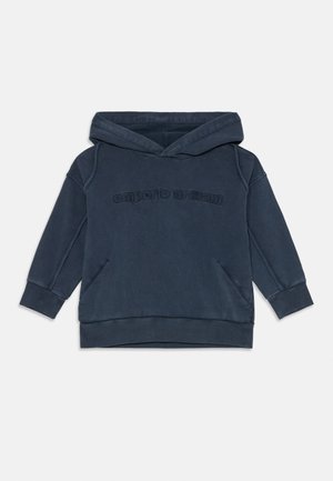 Temno modra kapuca iz mehkega materiala, z velikim sprednjim žepom in rebrastimi manšeti. Na sprednji strani je subtilno odtisnjeno "Emporio Armani".