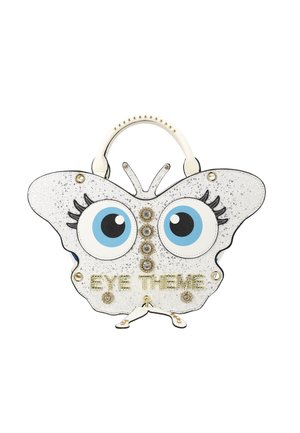 Witte handtas in de vorm van een vlinder met grote blauwe ogen, gouden studs en de tekst "EYE THEME" aan de voorkant, voorzien van een wit handvat met gouden studs.