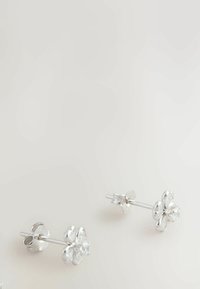 Cercei cu știfturi în formă de floare din argint, având trei accente asemănătoare petalelor și o piatră centrală clară. Finisaj neted, design minimalist.