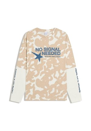 Camicia a maniche lunghe beige e bianca con motivo, con la scritta "NO SIGNAL NEEDED" e una stella blu sul davanti, e testo sulle maniche bianche.