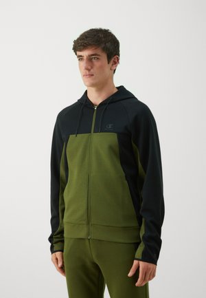 Kapuzensweatshirt mit Reißverschluss und einem Farbblockdesign in dunkelgrün und schwarz. Hergestellt aus weichem Stoff mit gerippten Bündchen und Saum.