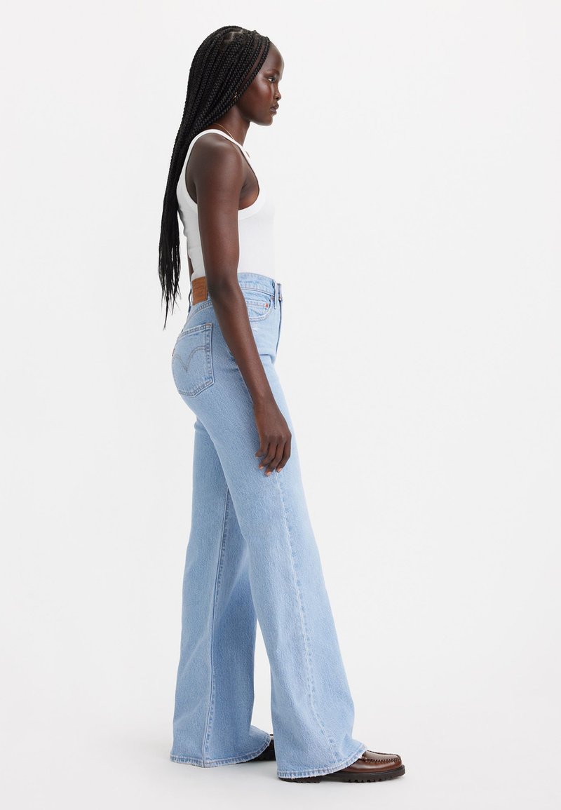 Helle blaue Denim-Jeans mit weitem Bein, hoher Taille, ausgefranstem Saum und einem klassischen Knopfverschluss. Verfügt über Gesäßtaschen und ein braunes Lederlabel.