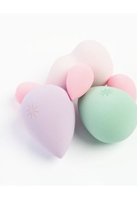 Set von Makeup-Schwämmen in Pastellfarben: Flieder, Pink und Minzgrün. Sie haben eine glatte, weiche Textur mit zarten floralen Gravuren.