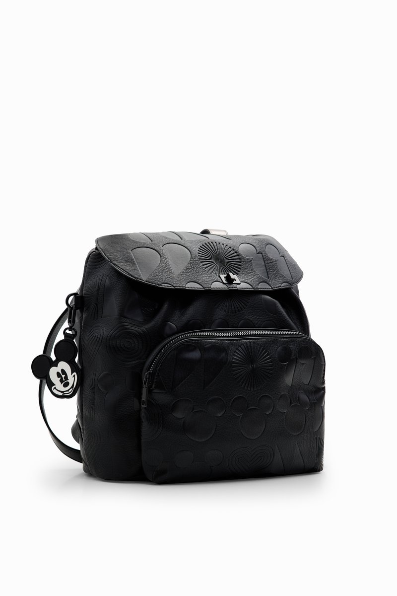 Black leather backpack with embossed circular and heart patterns, a flap closure, front zipper pocket, and Mickey Mouse charm attached.