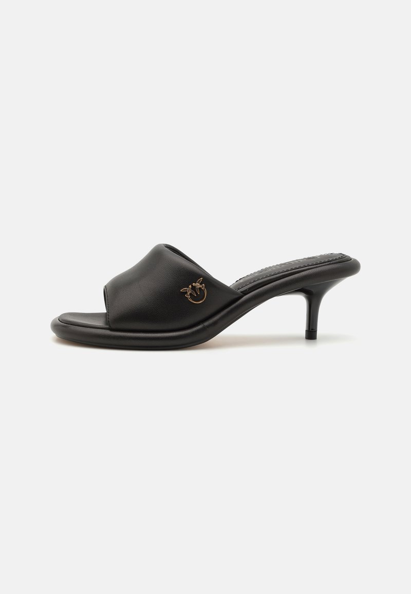 Black leather heeled mules with an open toe, curved design, and a gold-tone decorative detail on the upper. Smooth texture and slender heel.