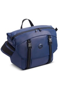 La borsa a tracolla blu navy presenta un materiale lucido e impermeabile, manico superiore, spallacci regolabili e un sottopatte con accessori neri.