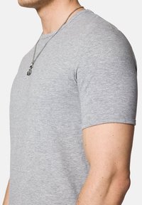 Szary krótki rękaw t-shirt wykonany z gładkiego materiału, z klasycznym okrągłym dekoltem i dopasowanym krojem, z widocznym łańcuszkiem na szyi.