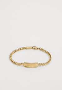 Gullkjedearmbånd med en glatt, oval tagg med det inngravere logoet. Kjededesignet har et teksturert, vridd utseende. Lås med clasp.
