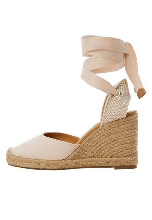 Beiger Espadrille Keilabsatzschuh mit geflochtenem Juteabsatz und Fesselriemen, geschlossener Spitze und strukturierter Rückseite.