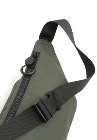 Borsa a tracolla verde oliva realizzata in tessuto testurizzato, con zip nera, tracolla regolabile e cierre in plastica per una chiusura sicura.